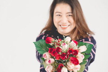 Asian smiling  woman on gray studio shot with red rose flower.