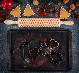 Christmas baking concept. Cookie cutters, gingebread cookies, rolling pin,  gift box, cinnamon and holiday decoration.