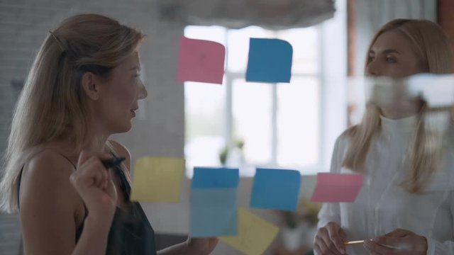 brainstorming in the office. Two serious business women engineer architect working on a project in the office. modern office, success concept 4K