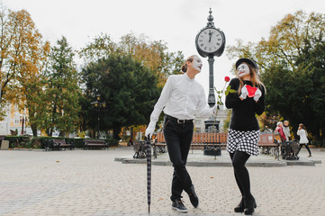 A couple of merry mimes. He hurries on a date.