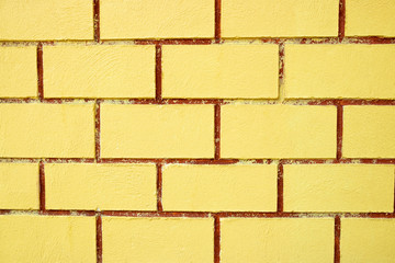 Abstract wallpaper texture stone yellow brick. Pattern on wall for abstract background. The yellow wall is divided into several small compartments.