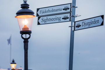 Street signs on a post on a wood background