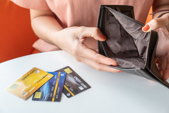 Close-up of woman hands open an empty wallet, Bad economics situation but she still have some credit cards. Conceptual of unhappy bankrupt woman.