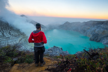 Tourist looking to Kawah Ijen volcano at dawn. Ijen volcano complex has some of the highest levels...
