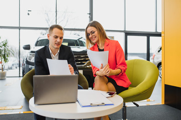 Successful businessman in a car dealership - sale of vehicles to customers