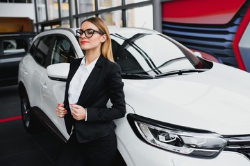 business woman buys a car at a car dealership. Concept of happy business people