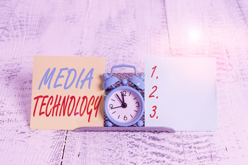Conceptual hand writing showing Media Technology. Concept meaning process of huanalysis origin that used to convey media Mini blue clock standing above buffer wire between two paper