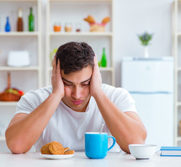 Man falling asleep during his breakfast after overtime work