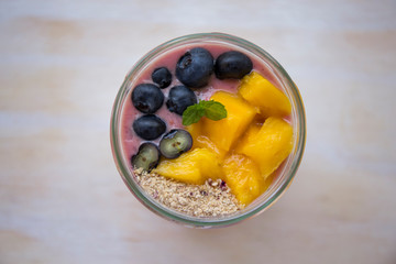 Chia pudding and acai smoothie with blueberries and mango on the wood table