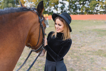 Obraz premium Portrait of young pretty cheerful woman with horse at summer