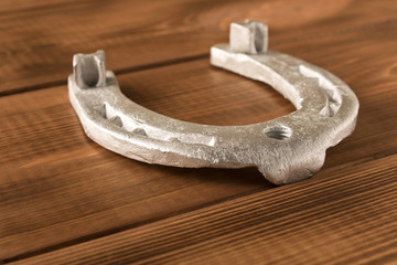 Silver horseshoe on a wooden table. An old horseshoe. Close up.