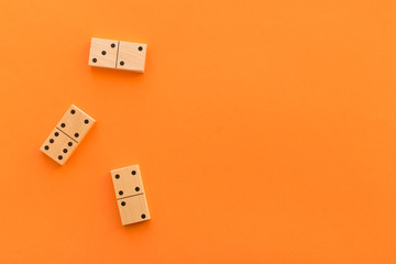 Playing dominoes on a orange table. Leisure games concept. Domino effect.