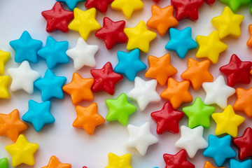 Isolated Candy Stars Close Up Colorful candy stars used for decorating cookies, treats and gingerbread houses. Macro view. White background. Fun and sweet. 