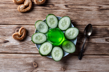 Fototapeta na wymiar Cucumber jelly on a saucer, with cookies on a wooden background