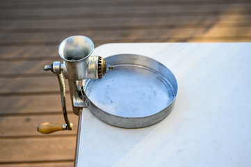 Manual clam grinder set up and ready to grind clams, catch pan and table outside