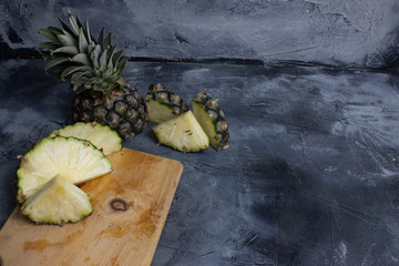 Slices of fresh Pineapple on simple grey background, from above. Top view. Copy space for designer.
