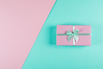 Pink gift box on a mint pink background. Two-color background. Holiday christmas birthday concept. Top view, flat lay, copy space