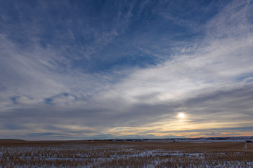sun setting behind clouds
