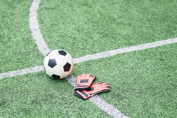 Sports gear on crossed lines of green empty field for trainings and matches