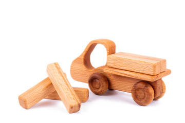 Close-up children's toy made of natural wood in the form of a dump truck  with wooden blocks in the form of cargo on a white isolated background. Studio photography. 