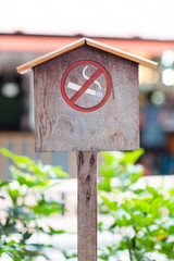 No smoking sign against a wood wall. The white non-smoking sign on the wooden floor is a sign that...