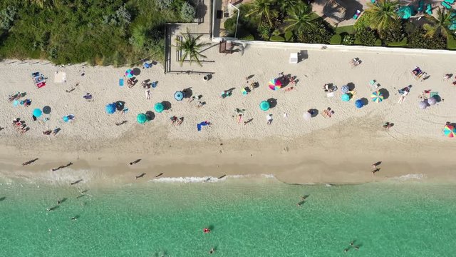 Aerial 4k footage of people have a good time on the beach in Miami beach