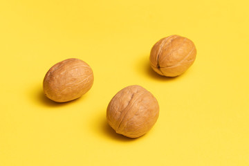 Delicious walnuts on bright yellow background.