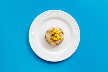 Birthday party for pets concept. Pet feed with festive candle in shape of three on blue background top-down