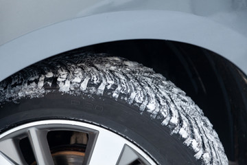 Close-up on a car wheel with tread Studded tires with little wear during filming for a safe birth...