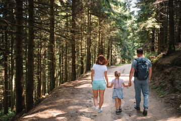 Obraz premium Young family with child resting on a forest
