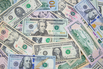 Money American dollar bills .Pile of various currencies isolated on white background. Closeup of assorted American banknotes.US currency scattered on the table. America currency.