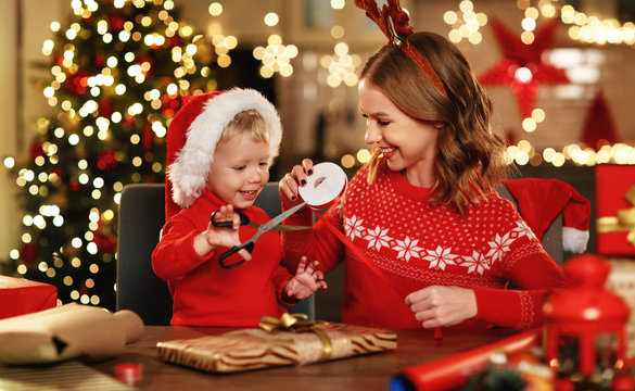 . happy family mother and child pack Christmas gifts.