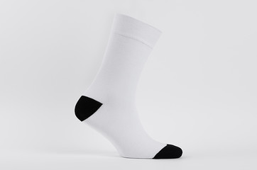 Blank white cotton long sock with black heel on invisible  foot on white background as mock up for...