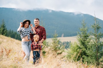 Obraz premium Young family with child resting on a mountain. vacation in the national park