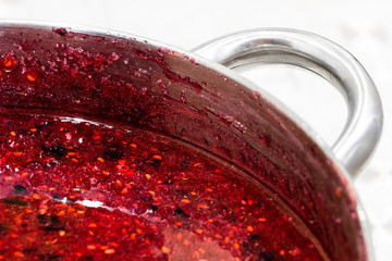 Cooking raspberry jam in a large pan.