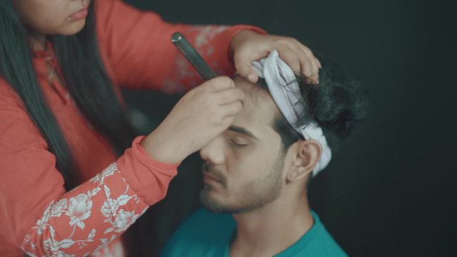 Professional make up artist putting face powder on man's face and doing the make up 
