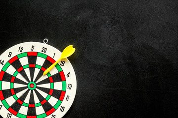 Goal achievement concept. Dartboard and arrows or dart on black background top view copy space