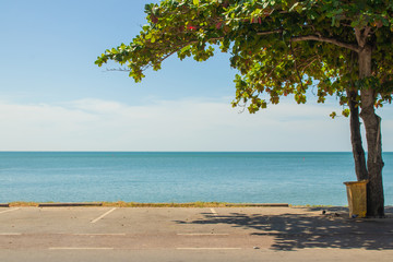 Empty space concrete car parking lot on the coast with beautiful seascape view in the background. (Selective focus)