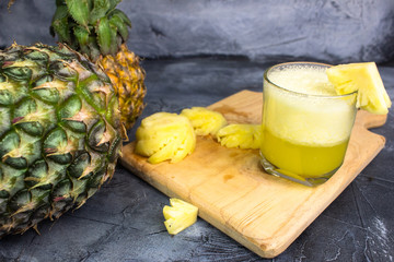 Fototapeta na wymiar pineapple juice on a gray background
