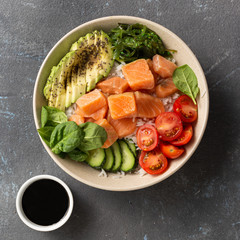 Tasty and healthy food concept Organic poke bowl with salmon, avocado, vegetables and chia seeds
