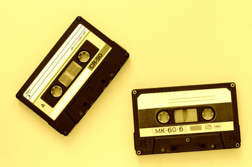 Two audio tape cassettes, top view. Old technology concept. Yellow color toned
