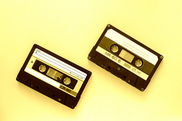 Obraz premium Two audio tape cassettes, top view. Old technology concept. Yellow color toned