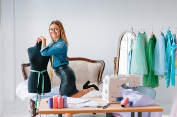 Working on new collection. New order. Female fashion designer works on the new clothes in the...