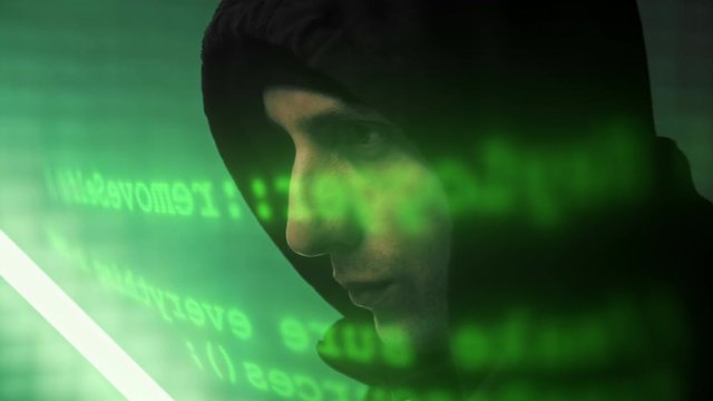 Close-up of the russian hacker working on a computer while green code characters running infront of his face in a dark office room. 4K (UHD)