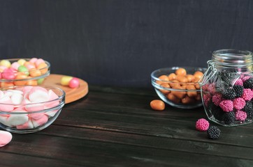 multi-colored candies in a plate, bank and bowls with copy space - 306834427