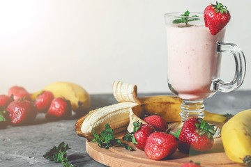 banana and strawberry smoothies with mint on the table, front view - 306834479