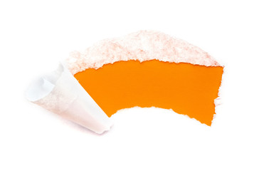 A hole in white paper with torn edges isolated on a white background with a bright orange color paper background inside.