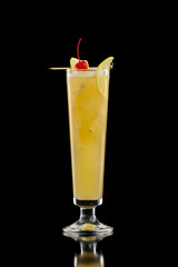 Closeup glass of orange juice cocktail decorated with cherry isolated at black background.