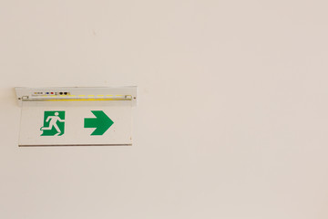 Green emergency exit sign showing the way to escape.Fire exit in the building.