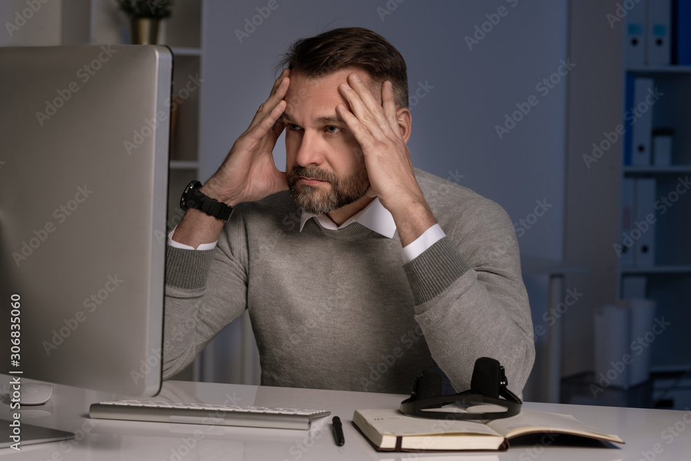 Aufkleber Serious and troubled office worker touching head in front of computer screen